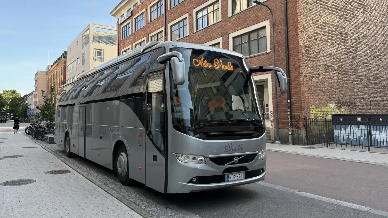 Atro Vuolteen hopeanharmaa tilausbussi Tampereen keskustassa