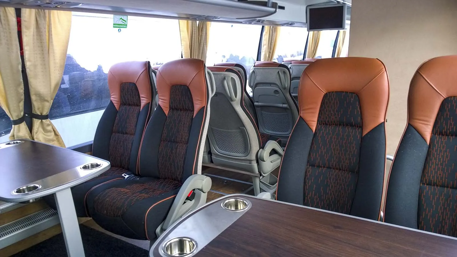 Kokousbussin nahkaverhoiltu matkustamo pöytäryhmineen