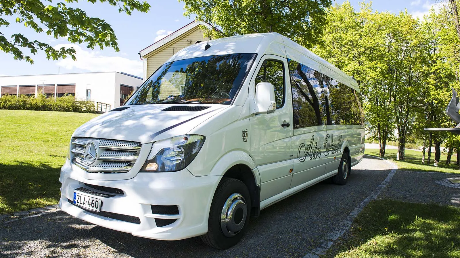 Valkoinen Atro Vuolteen Mercedes-Benz-pikkubussi kesäisessä puistossa