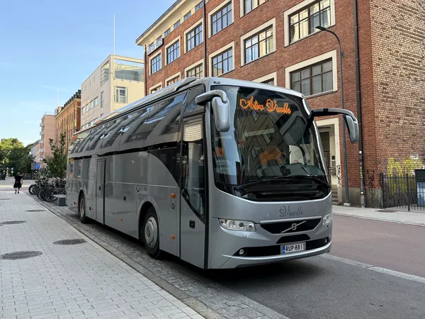 Atro Vuolteen tilausbussi odottaa yrityksen henkilöstöä kaupungin kadulla