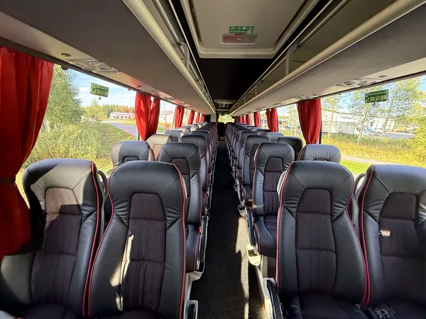 Tilausbussin matkustamo: nahkaverhoillut, turvavyölliset istuimet ja keskikäytävä