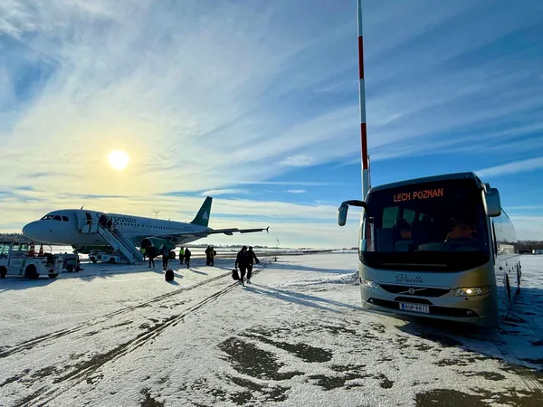 Atro Vuolteen tilausbussi noutaa joukkueen lentokoneen vierestä
